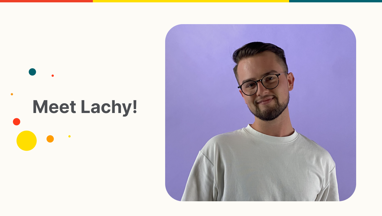Portrait of Lachlan Smith a smiling young man with short brown hair, glasses and a trimmed beard, wearing a white t-shirt against a soft purple gradient background