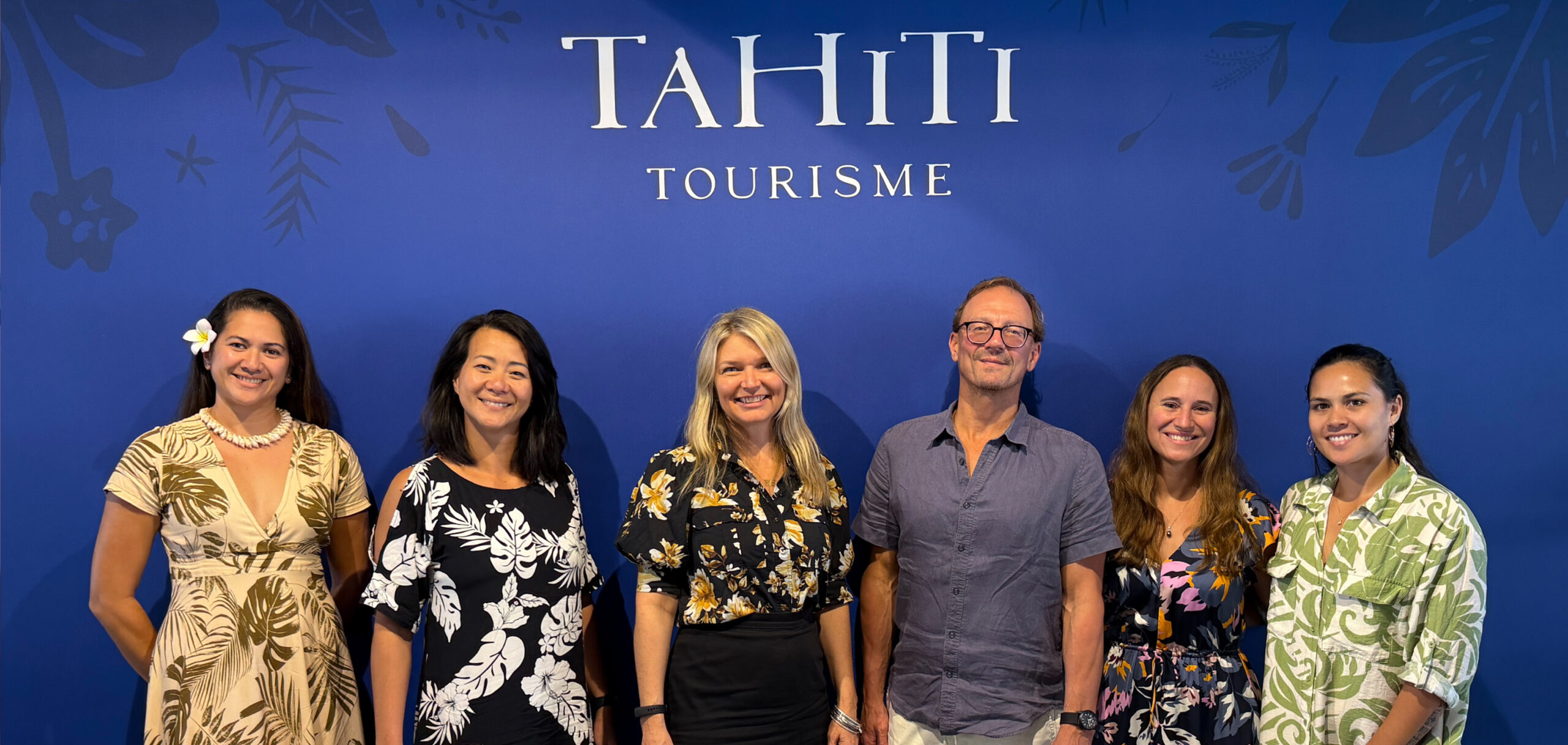 Circul8 and Tahiti Tourisme representatives standing in front of a Tahiti Tourisme branded backdrop.