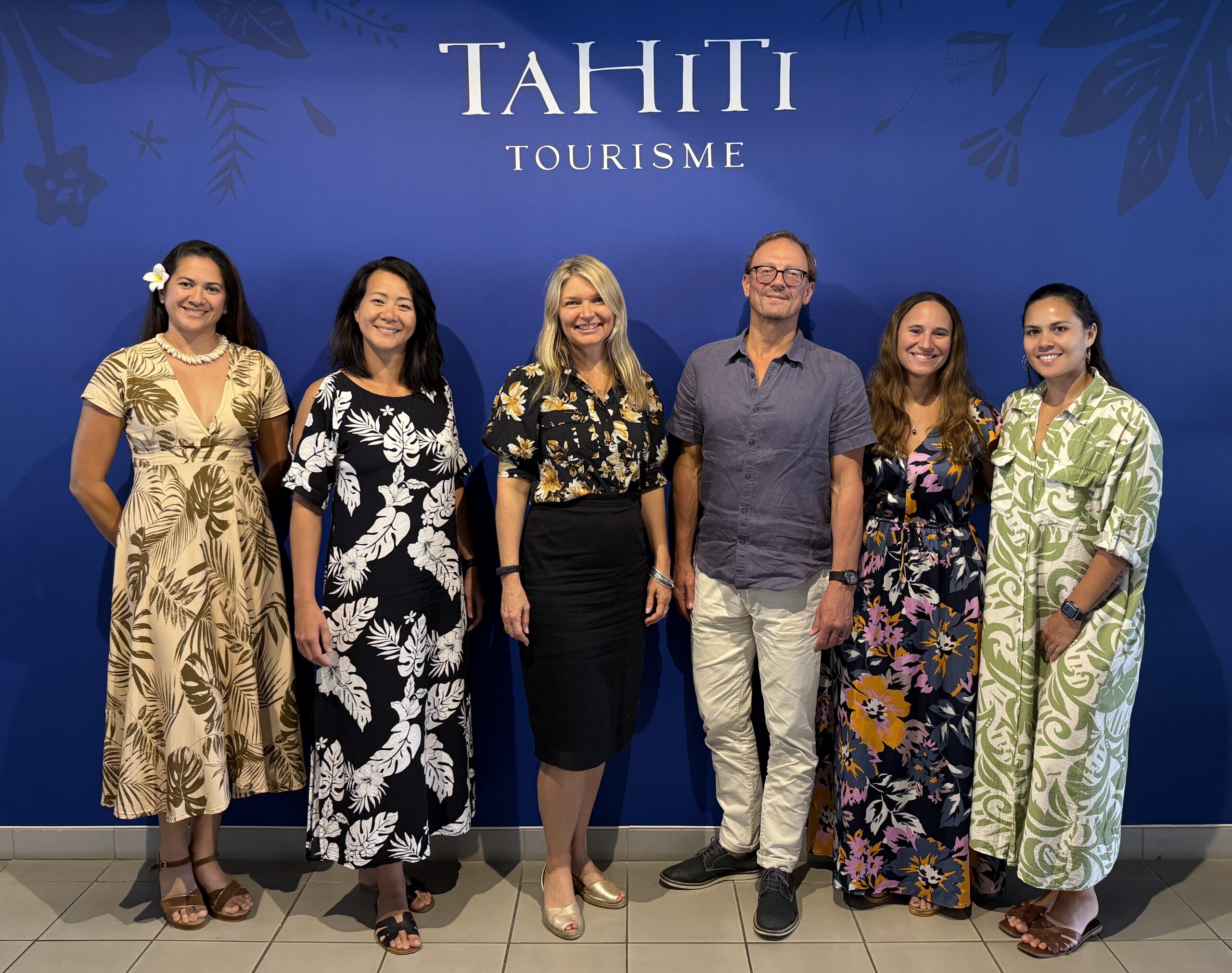 Circul8 and Tahiti Tourisme representatives standing in front of a Tahiti Tourisme branded backdrop.